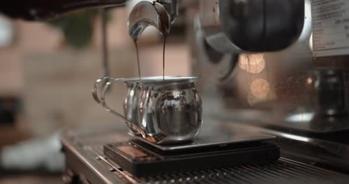 Coffee pours coffee into two cups in a cafe closeup