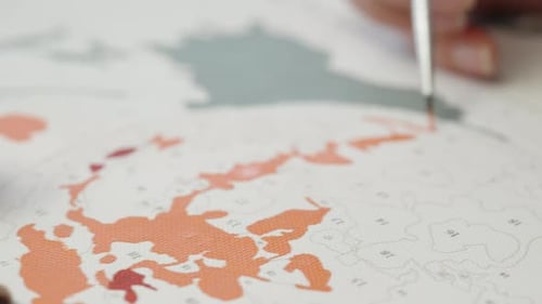 Painting by Numbers with Orange Paint and Brush