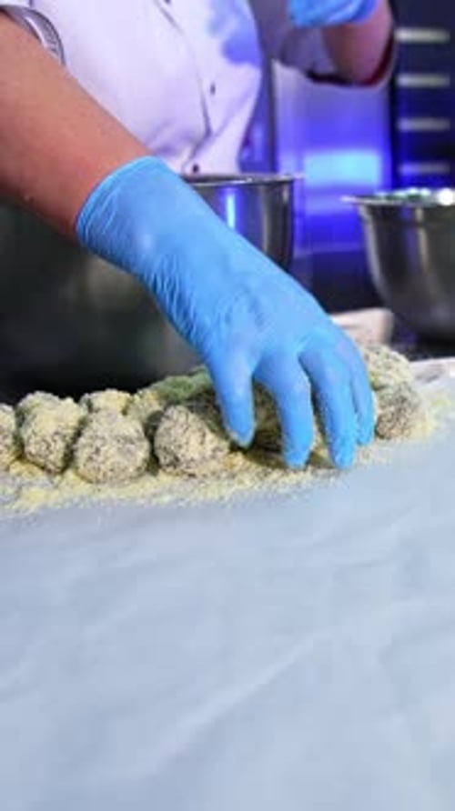 Der Konditorei bestreut die Kekse mit Streuseln.