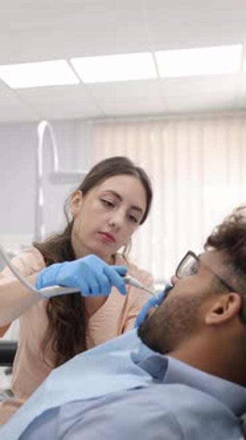 Female Dentist Performing Dental Procedure on Patient
