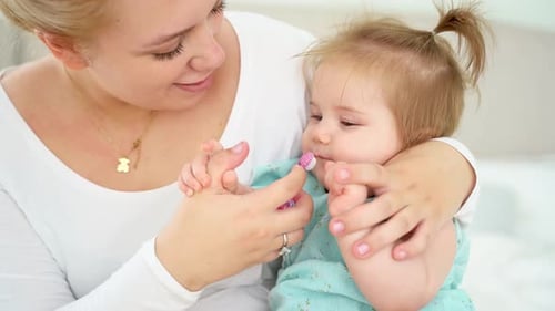 Mother Gently Brushing Toddler's Teeth