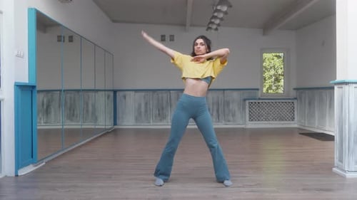 Dancer gracefully performs fluid and elegant movements in a dance studio.