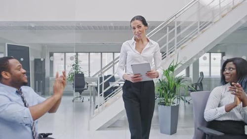 Die schöne, glückliche Geschäftsfrau, Managerin, wird von ihren Kollegen wegen Suc bejubelt und gefeiert