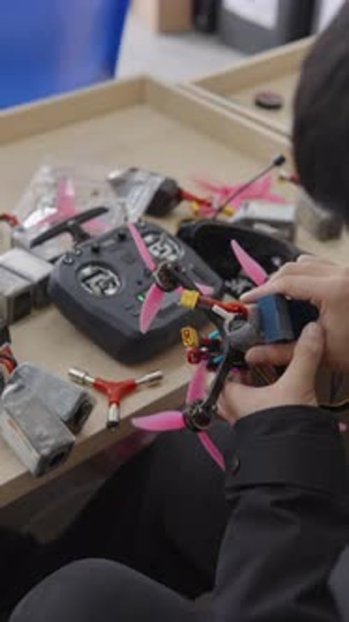 Worker Assembling FPV Drone at Small Chinese Factory Illustrating Mass Production of Unmanned Aerial