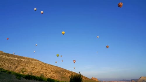 Heißluftballons fliegen über strahlend blauem Himmel, Kappadokien, Türkei