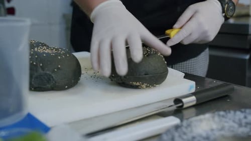 A professional chef is preparing a hamburger in his kitchen - 05