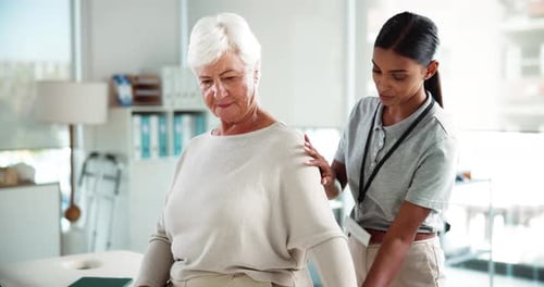 Therapist Assisting Senior with Shoulder Exercises