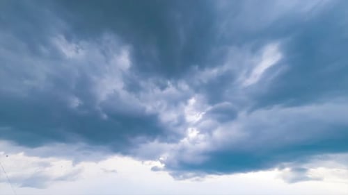 Cloud mass moving around the sky. Dark clouds spreading in the sky.