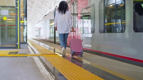 Young Woman is Travelling By Train in Suburban Area Rear View of Walking Female Passenger