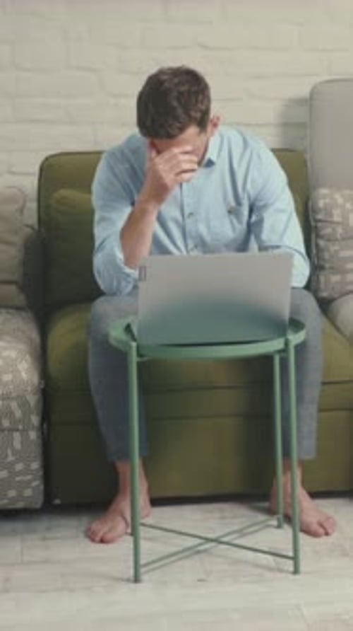 Stressed Man Working on Laptop At Home