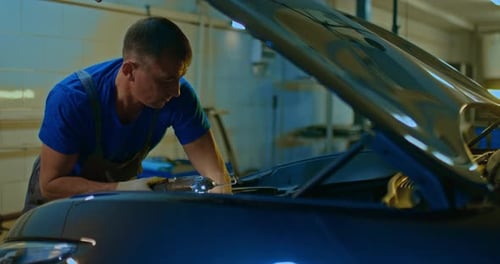 Auto Mechanic Checks the Car Engine Under the Hood