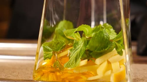 Lemon Ginger and Mint being added to glass