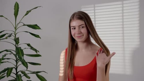 Portrait of Sweet Pretty Brown Haired Girlfriend in Red Singlet Over White Studio on Background