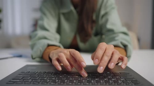 Woman Typing on Laptop Keyboard in Office