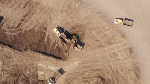 Excavator loading soil onto a Truck, Aerial view.