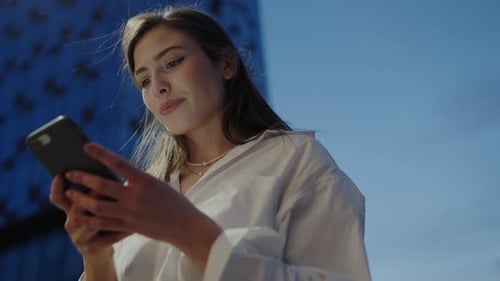 Woman Using Phone in Urban Setting