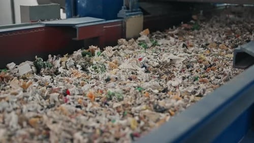 industrial rubber scraps moving along conveyor inside recycling plant