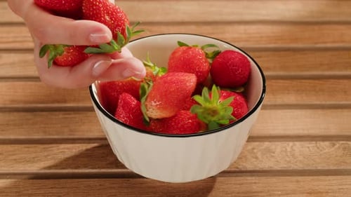 Fresh Flavorful Strawberries Beautifully Arranged in Hands Resting on a Wooden Table