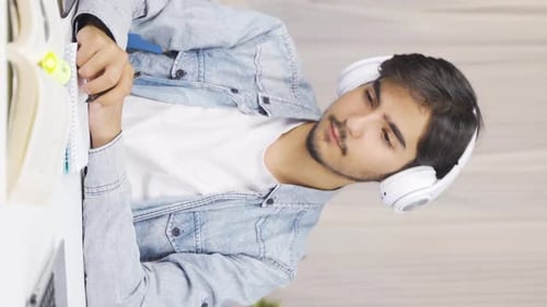 Young Man Studying with Headphones On