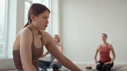Women Practicing Yoga and Meditation in Bright Studio