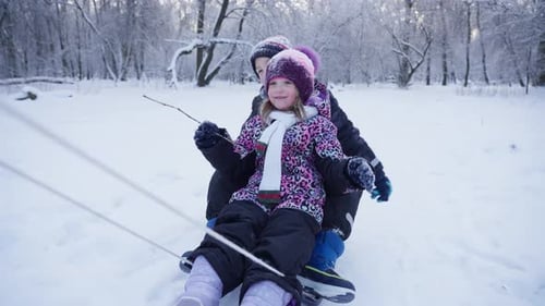 Happy Children Riding Sleds Through Snow Covered Forest Winter