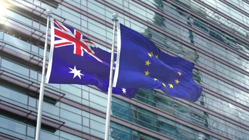 Australia and European Union Flags Waving Against Modern Building