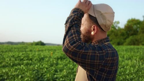 Hardworking Tired Farmer Standing on Field Looking