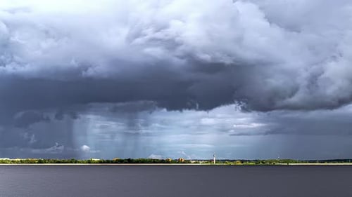 Zeitraffer von Gewitterwolken, die sich über der Stadt sammeln und Regenblätter abwerfen