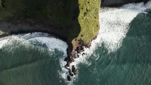 Breathtaking Aerial View of Ocean Waves Crashing Against Coastal Cliffs
