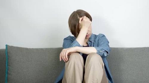 Sad Woman Sitting on Couch Crying