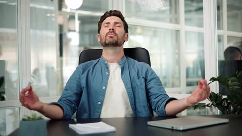Man Meditating at Desk in Modern Office