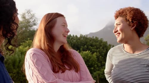 Three Friends Laughing Together Outside in Sunlight