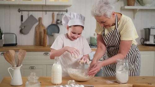 Child and Senior Woman Baking Together in Kitchen