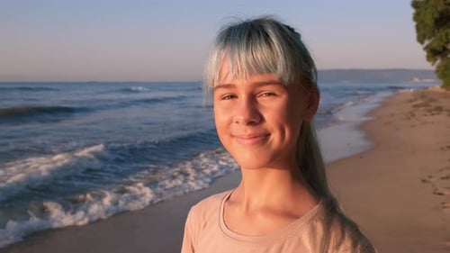 Smiling teen face against ocean.