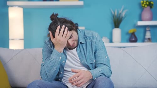 Young Man Sitting on Couch Speaking Indoors
