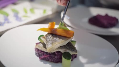 The Chef Decorates an Elegant Fish Fillet Dish for the Buffet at the Hotel