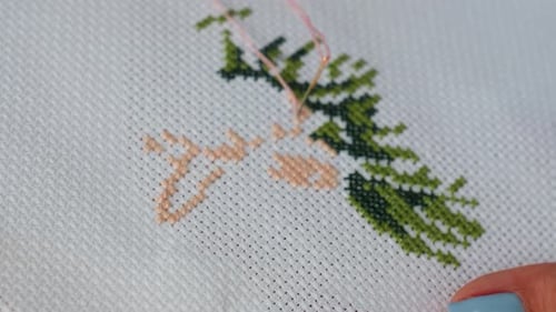 Extreme Close Up Of Craft Person Embroidering Green Tree On White Fabric