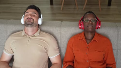 Man and Woman Relaxing, Meditating with Eyes Closed Indoors