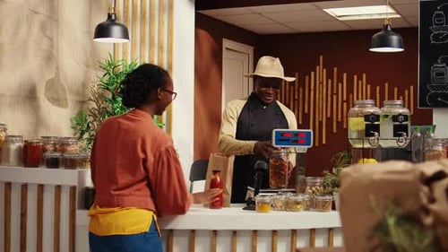Man Serving Customer at Natural Grocery Store Counter