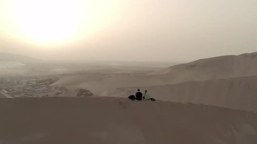 Aerial of couple on sand dunes outside of Ica, Peru near Huacachina.