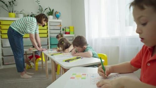 Children Drawing with Teacher in Bright Classroom