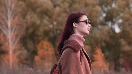 Auburn Haired Woman in Autumnal Landscape Posing Sideways