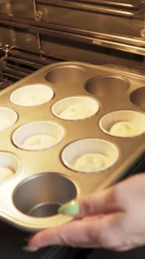 Forms filled with dough are put in the oven for baking. Close-up Vertical video.