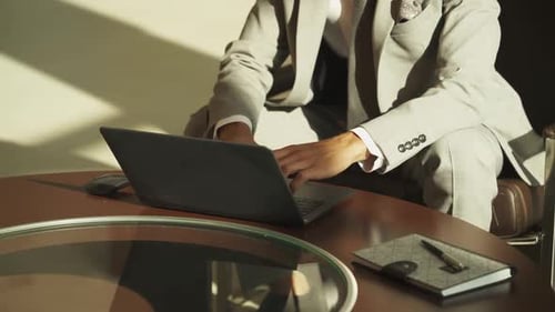 Elegant Businessman in a Suit Working on a Laptop Coworking a Businessman Working on the Go