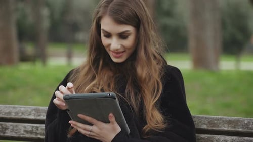 Woman Using Tablet Outdoors in Park Setting