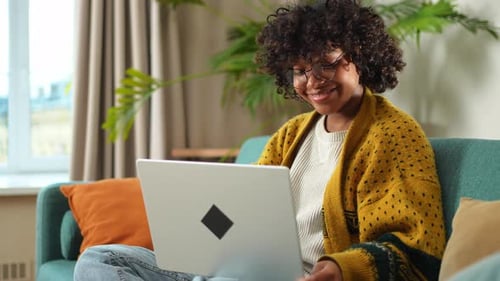 African American Girl Using Laptop at Home Office Looking at Screen Typing Chatting Reading Writing