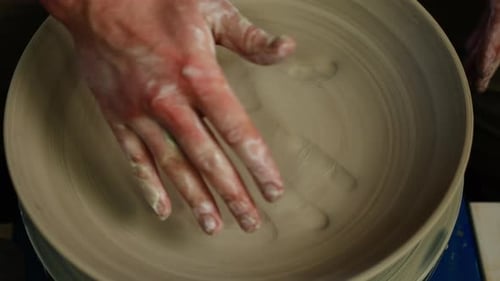 Man Artisan in Pottery Workshop Making Clay Pot on Rotary Machine