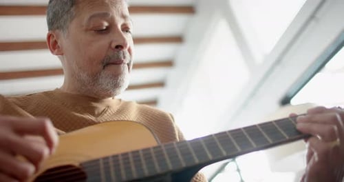 Man Plays Acoustic Guitar Close Up in Home