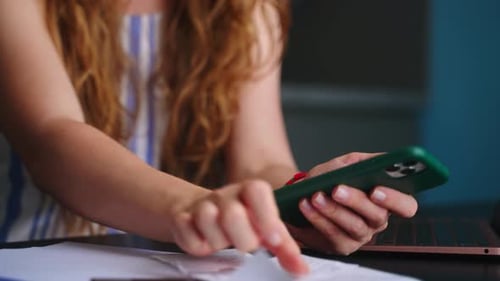 Woman Reviews Receipts, Uses Smartphone