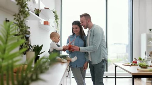 Adorable Family of Three Toasting Fresh Drinks at Home